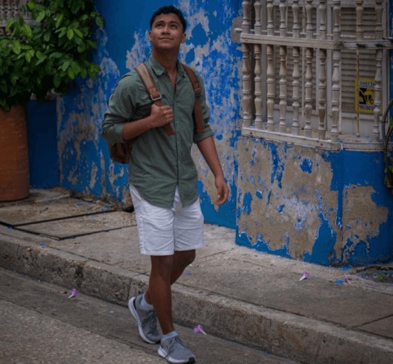 This is a picture of Eduardo with a colonial structrure behind him